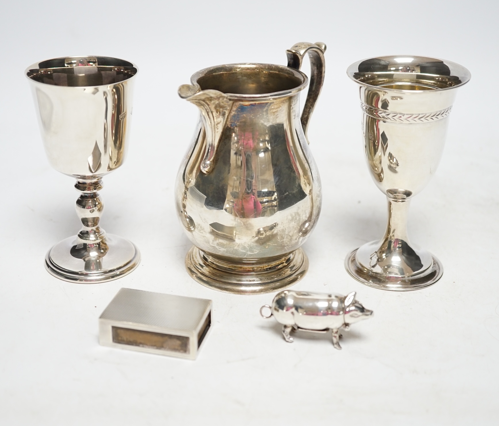 Sundry silver including a modern pig vesta case, two goblets, a match box sleeve and modern cream jug. Fair condition.
